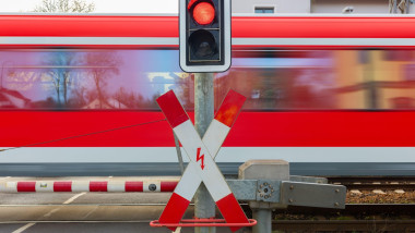 Germany, Fast Regio Train is crossing street with red traffic light