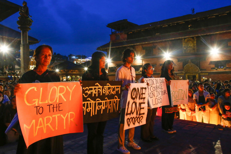 Mourners hold placards during a candlelight vigil for the 71 people killed in the Gen Z protests in Lalitpur.