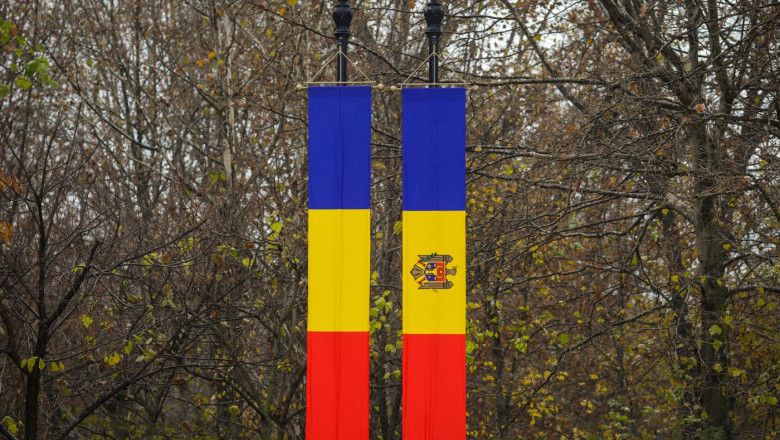Details with the Romanian and Republic of Moldova flags with autumn trees in the background.