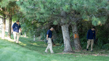 Law enforcement officials, including members of an FBI forensics team, investigate a wooded area near the crime scene where political activist Charlie Kirk was shot and killed at Utah Valley University in Orem, Utah