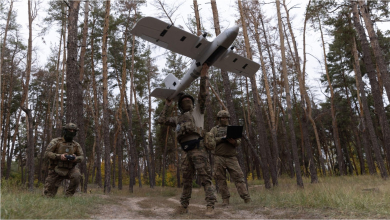 soldați ucraineni lansează o dronă într-o pădure