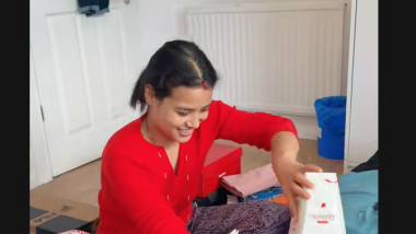 o tanara nepaleza imbracata in rosu umple bagajul cu dulciuri