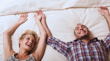 Couple relaxing on hotel room bed