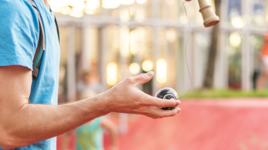 copil se joaca cu kendama