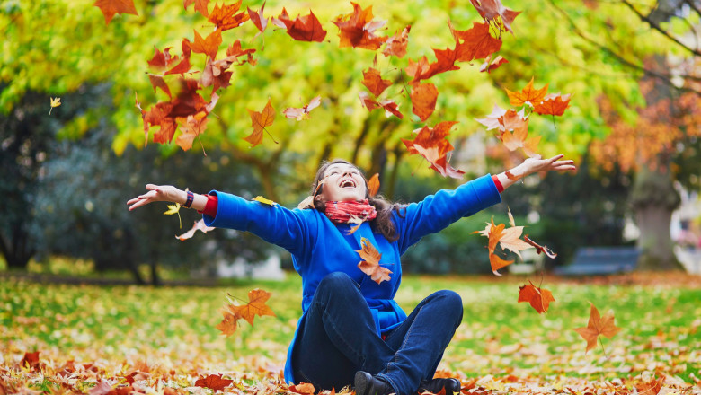 femeie pe jos si frunze de toamnă