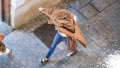 Valencia, Spain. September 28, 2025. People take cover from heavy rainfall after the Generalitat Valenciana government declared a red alert for heavy rain, just 11 months after the DANA tragedy that left 229 dead. Credit: Eduardo Ripoll Vidal/Alamy Live N