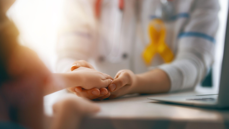 World Childhood cancer Day. Girl patient listening to a doctor in medical office.