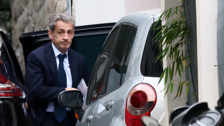 Former French President Nicolas Sarkozy leaves his car as he arrives at his home after being notified of his incarceration date by the National Financial Prosecutor's Office