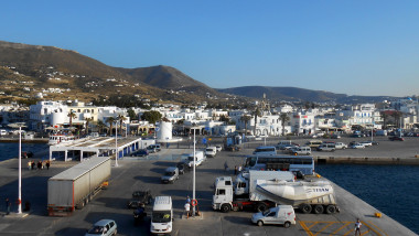 Cars waiting to embark on a ferry line up at the port of the island of Paros