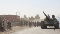 An Afghan Taliban fighter sits on a tank near the Afghanistan-Pakistan border in Spin Boldak, Kandahar Province, following exchanges of fire between Pakistani and Afghan forces