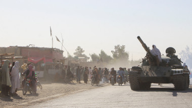 An Afghan Taliban fighter sits on a tank near the Afghanistan-Pakistan border in Spin Boldak, Kandahar Province, following exchanges of fire between Pakistani and Afghan forces