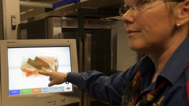 A security officer shows the screening of a passenger's hand luggage containing two bottles with liquids at a security gantry at Zurich airport