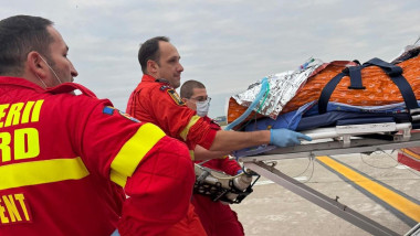 pacient ars scos pe targa din avion, ambulantieri langa el