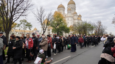 O multime de oameni urmareste ceremonia de sfințire a picturii Catedralei Mântuirii Neamului (Catedrala Națională) din afara curtii catedralei, în București, 26 octombrie 2025