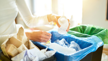 femeie sorteaza deseurile