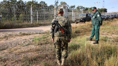 Bulgarian border police personnel stand near the fence, built across the Bulgarian-Turkish border