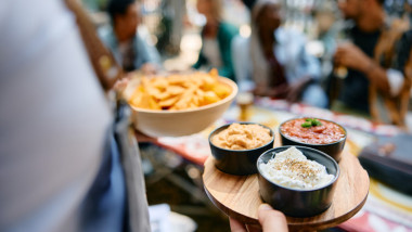 un ospatar serveste mancare la masa