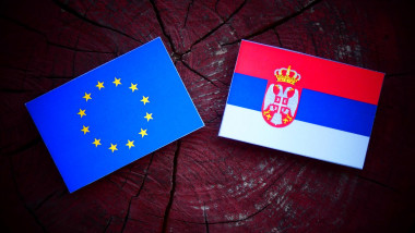 EU flag with Serbian flag on a tree stump isolated