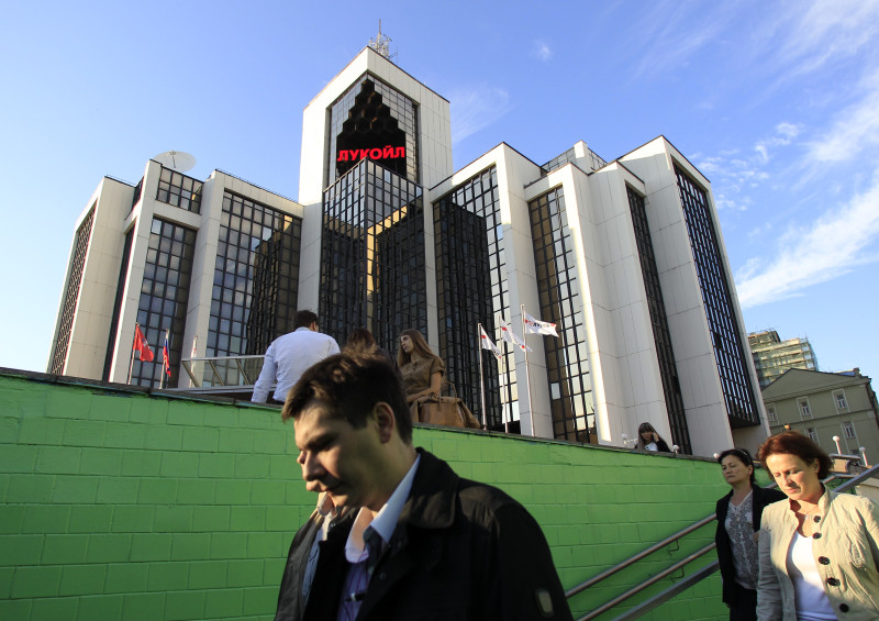 People walk down into an underground walkway near the Lukoil company headquarters in Moscow