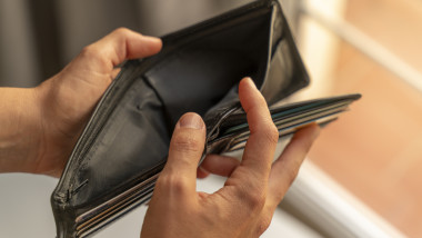 barbat se uita in portofelul gol