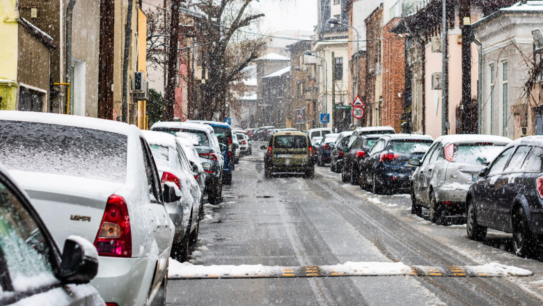 Snowing on cars in the morning, snow on street in Bucharest, Romania, 2021
