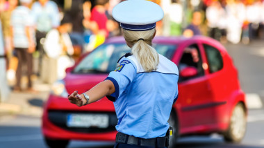 Bucharest, Romania - August 04, 2019: A policewoman directs cars traffic at an intersection in Bucharest.