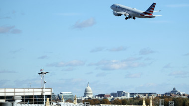 avion in zbor si casa alba in fundal