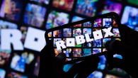 LONDON, UK - March 2021: Person holding a smartphone with Roblox game logo