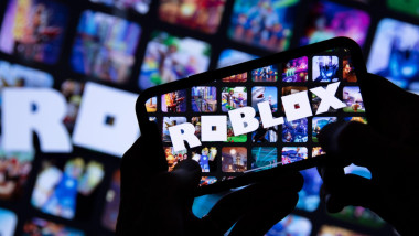 LONDON, UK - March 2021: Person holding a smartphone with Roblox game logo
