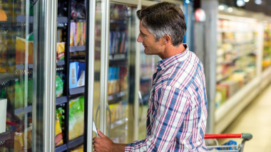 Man opening supermarket fridge