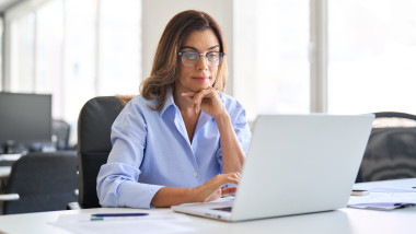 Busy,Elegant,Middle,Aged,Business,Woman,Using,Laptop,Working,In