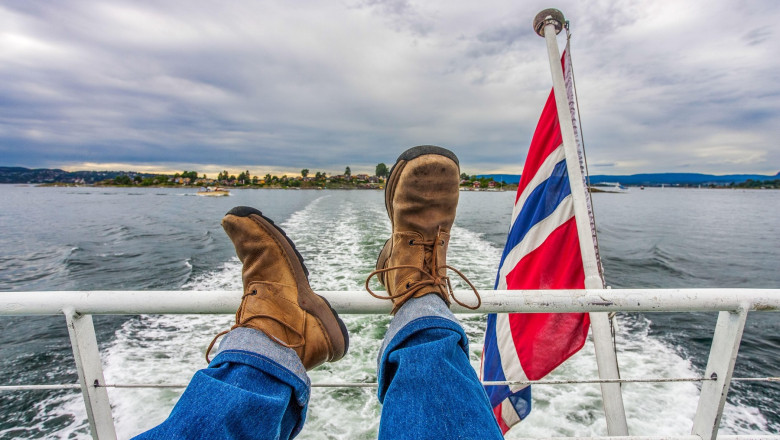 Feet on a boat railing, cruising Oslo's calm waters—capturing pure relaxation in Norway's stunning scenery.