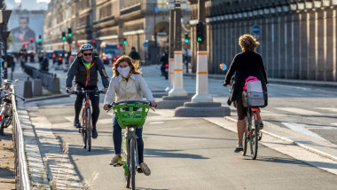 Paris, France - May 14, 2020: Young woman on her bike with a surgical mask to protect herself from covid-19 in a street in Paris