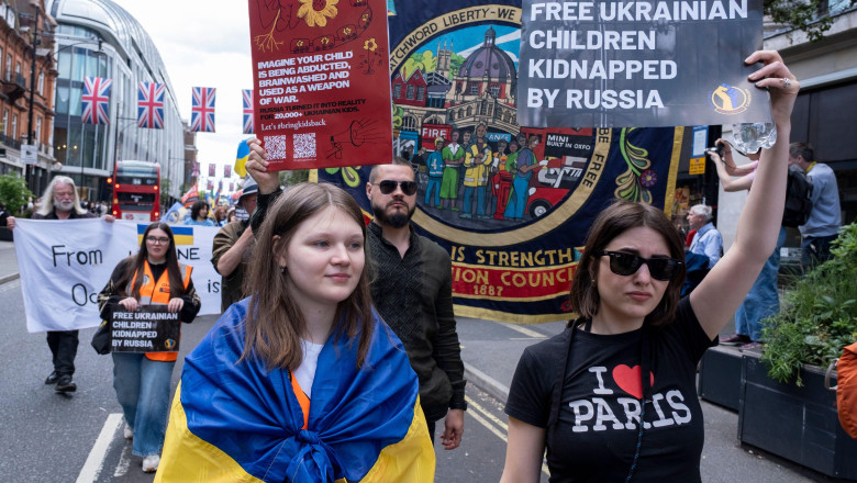 People holding placards which read Free Ukrainian children kidnapped by Russia at the March for the children of Ukraine at the March for the children of Ukraine on 1st June 2025 in London, United Kingdom. This demonstration was organised by Ukraine Solida