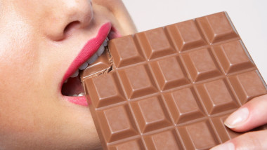 Woman biting huge bar of chocolate
