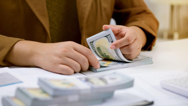 Businessman analyzing investment charts and pressing calculator buttons over documents. Accounting Concept
