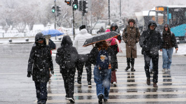 oameni cu umbrele pe lapovita