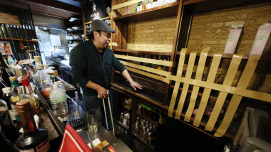 An employee cleans up at an "izakaya" pub in Hachinohe, Aomori Prefecture, on Tuesday, Dec. 9, 2025, in the wake of a huge earthquake that rocked northeastern Japan the night before