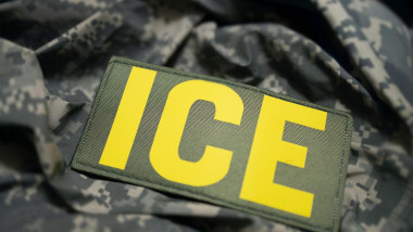 Close up shot of a uniform patch embroidered with white letters: “ICE.” Anti immigration protests.
