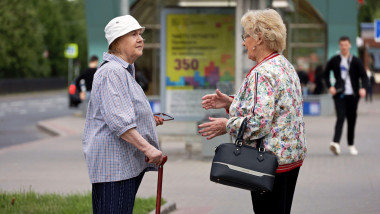 Two old woman talking on a street. Life of retirees in city