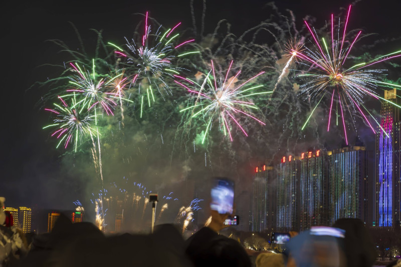 JILIN, CHINA - DECEMBER 31: People watch the firework show along the Songhua river on New Year s Eve on December 31, 202