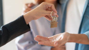 cheie cu un breloc cu casa si un cuplu in spate