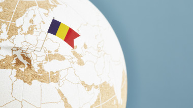 A world globe with a Romanian flag pin showing Romania