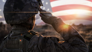 Female Solider Saluting US Flag at Sunrise