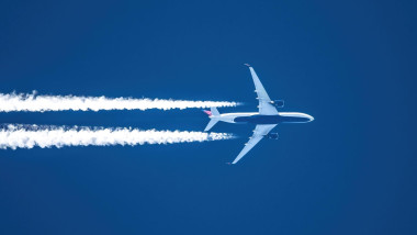 Sharp telephoto close-up of jet plane aircraft with contrails cruising from Seoul to Atlanta at 39,000 feet, ground speed 516 knots over British Colum