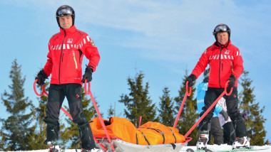 2 salvamontisti pe schiuri cu targa