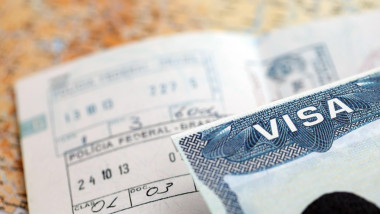 US Embassy visa in passport page with stamps on office table close up