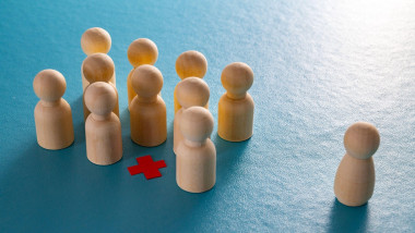 Conceptual representation, with wooden pawns, of corporate layoffs. Concept of layoffs, staff cuts, and mass layoffs