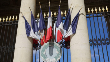 cluster of French flags on the facade of the Bourbon Palace, seat of the National Assembly in Paris, France