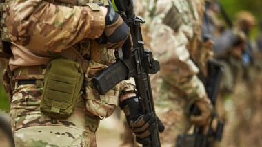 Group of Ukrainian soldiers equipped with modern American assault rifle training at the shooting range outdoor. Armed forces of Ukraine fighting for freedom and protecting the country